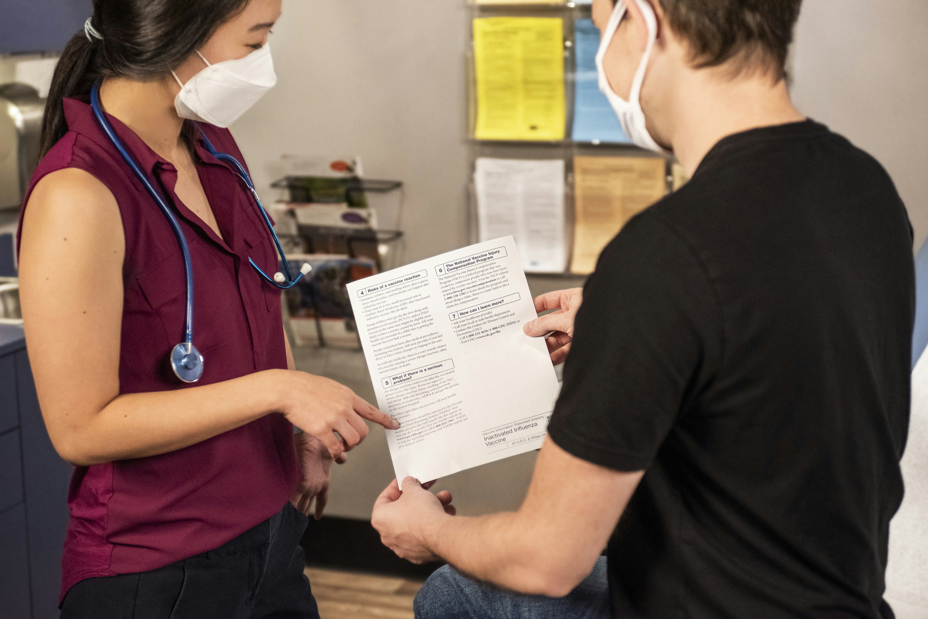 Healthcare clinician reviewing intake paperwork with a patient in a clinic setting